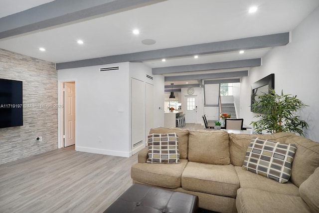 living room with light hardwood / wood-style floors and beam ceiling