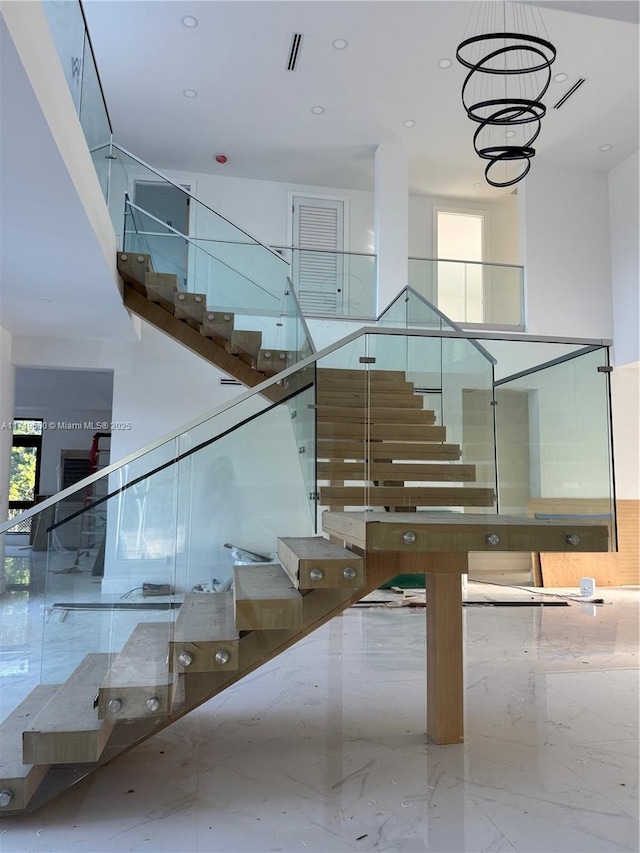6190 SW 128th St, Pinecrest, FL 33156 - stairway featuring marble tiled floors, healthy amount of natural light, a towering ceiling, a chandelier, and recessed lighting