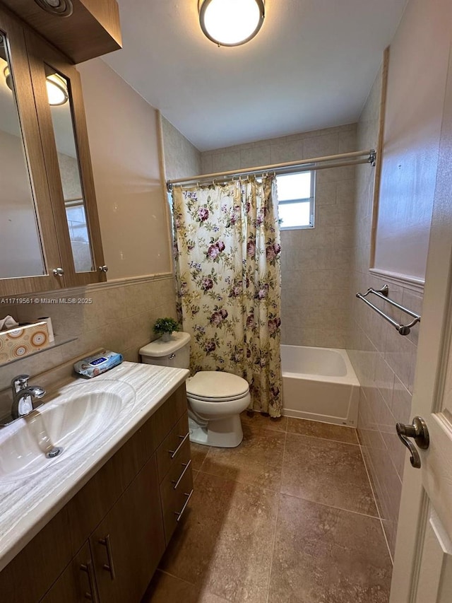 full bathroom with shower / tub combo with curtain, vanity, tile walls, and toilet