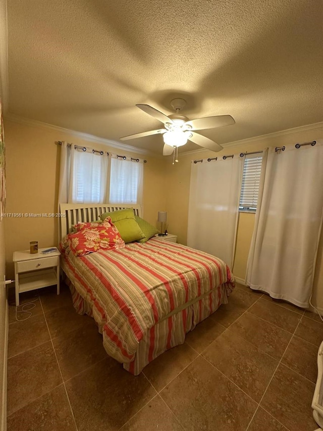 tiled bedroom with ceiling fan, a textured ceiling, and ornamental molding