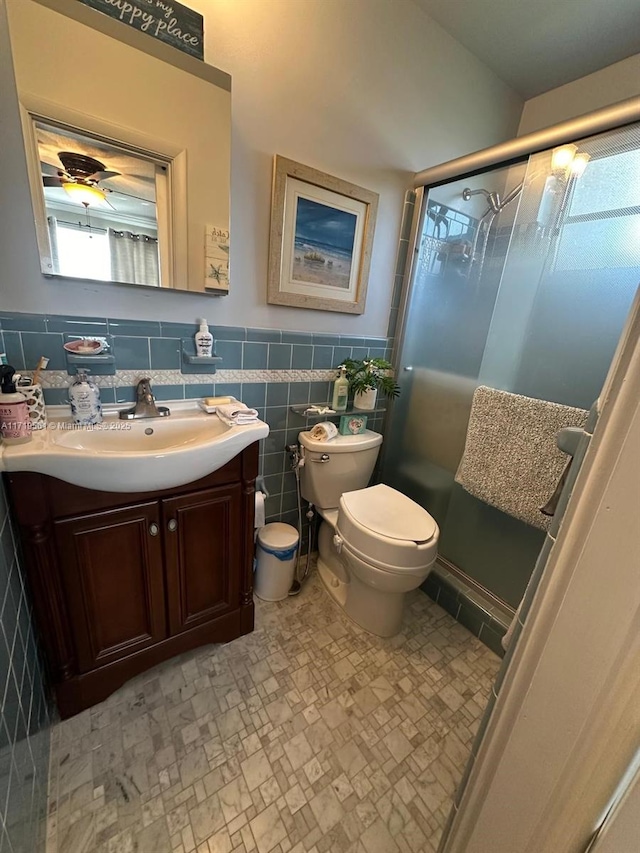 bathroom featuring vanity, toilet, tile walls, and walk in shower