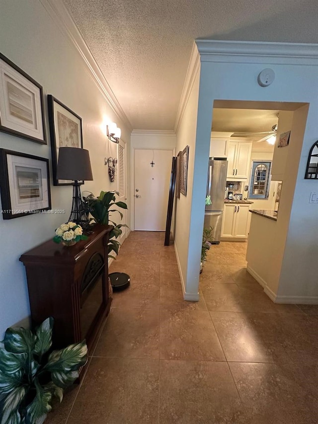 hallway featuring ornamental molding and a textured ceiling