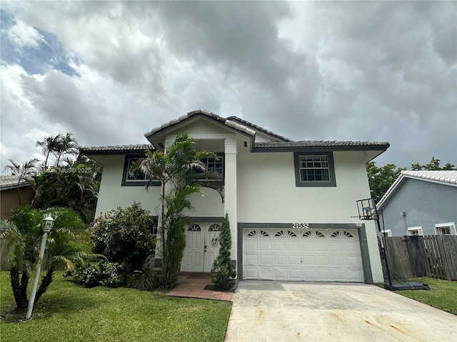 mediterranean / spanish-style home featuring a garage and a front lawn