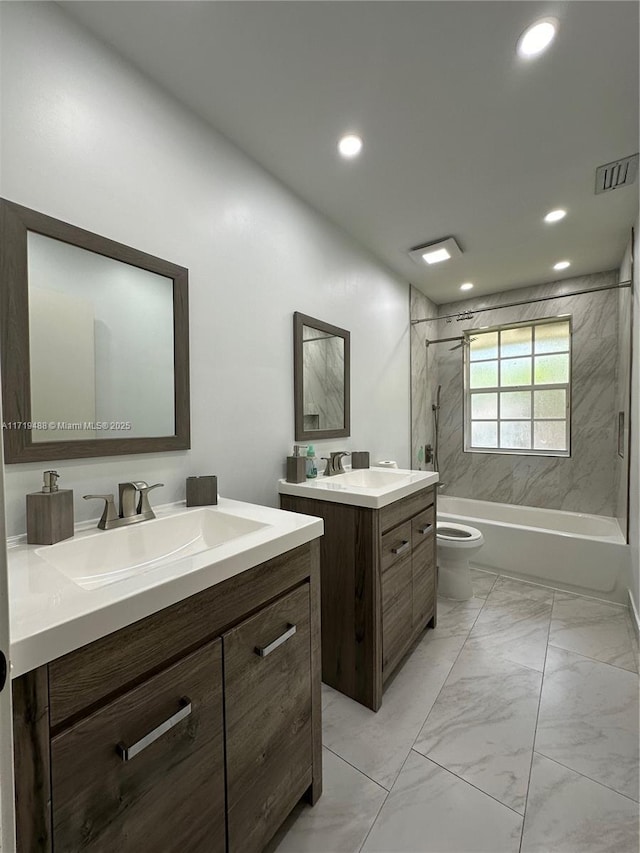 full bathroom featuring tiled shower / bath, vanity, and toilet