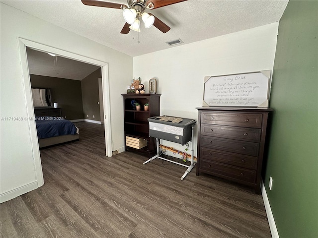 miscellaneous room with ceiling fan, dark hardwood / wood-style flooring, and a textured ceiling