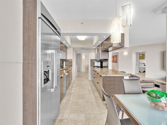 kitchen with modern cabinets, tasteful backsplash, and appliances with stainless steel finishes