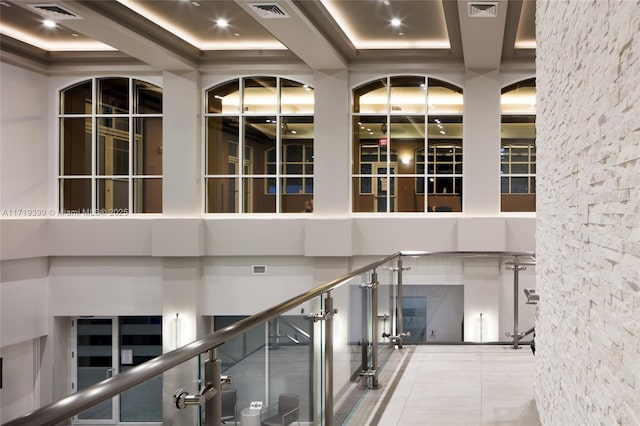 stairway with visible vents, a raised ceiling, and a high ceiling