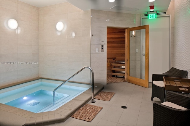 bathroom with tile patterned floors, tile walls, and tiled bath