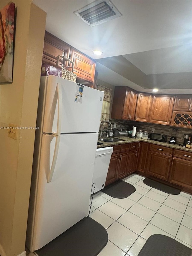 kitchen with backsplash, white appliances, sink, and light tile patterned floors