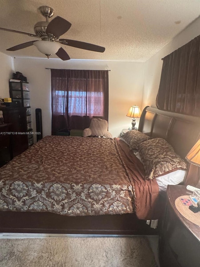 bedroom with ceiling fan and a textured ceiling