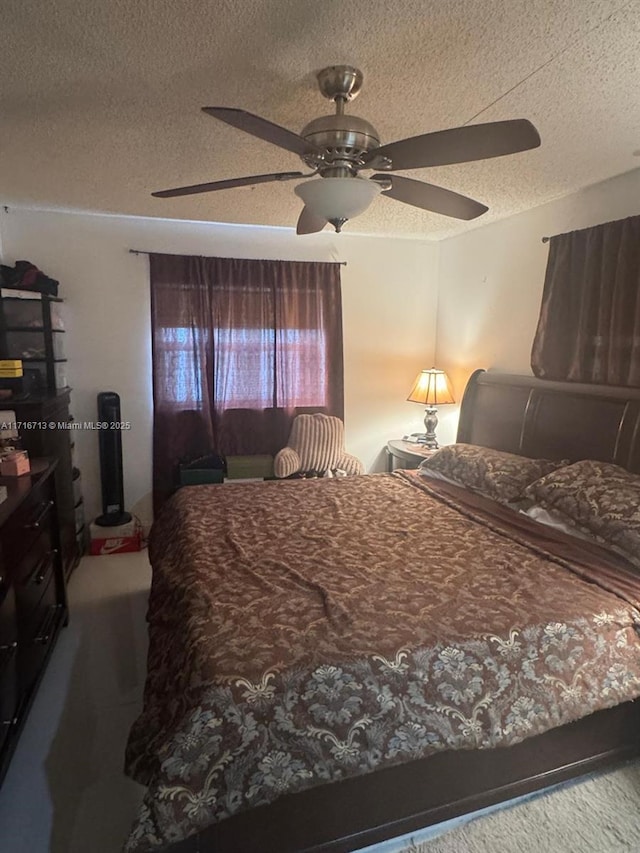 bedroom with ceiling fan and a textured ceiling