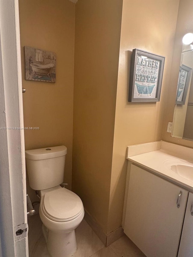 bathroom featuring tile patterned flooring, vanity, and toilet