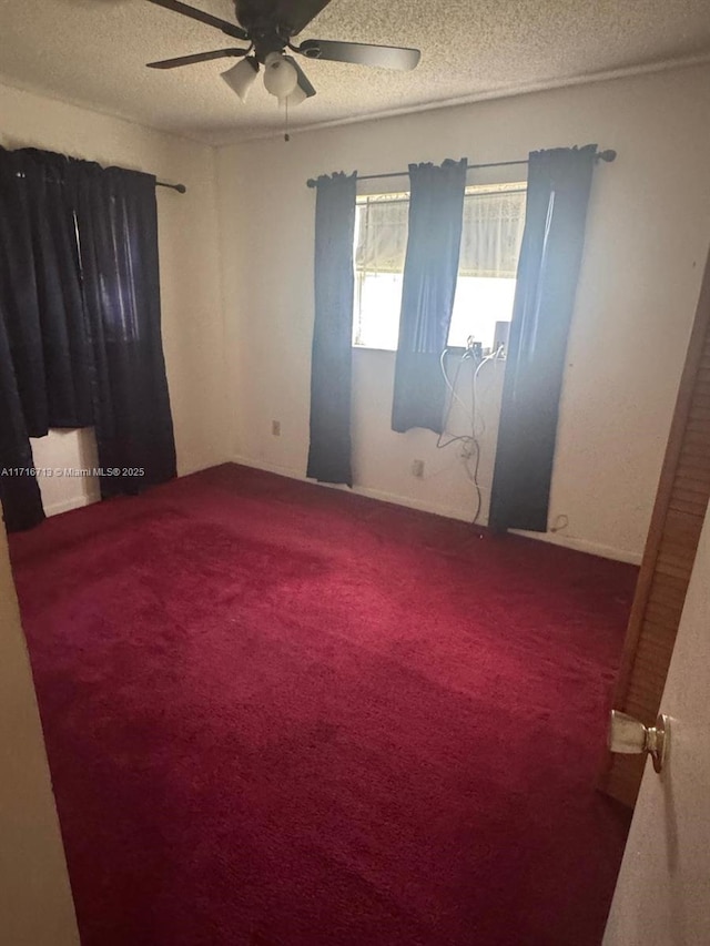 carpeted spare room with a textured ceiling and ceiling fan