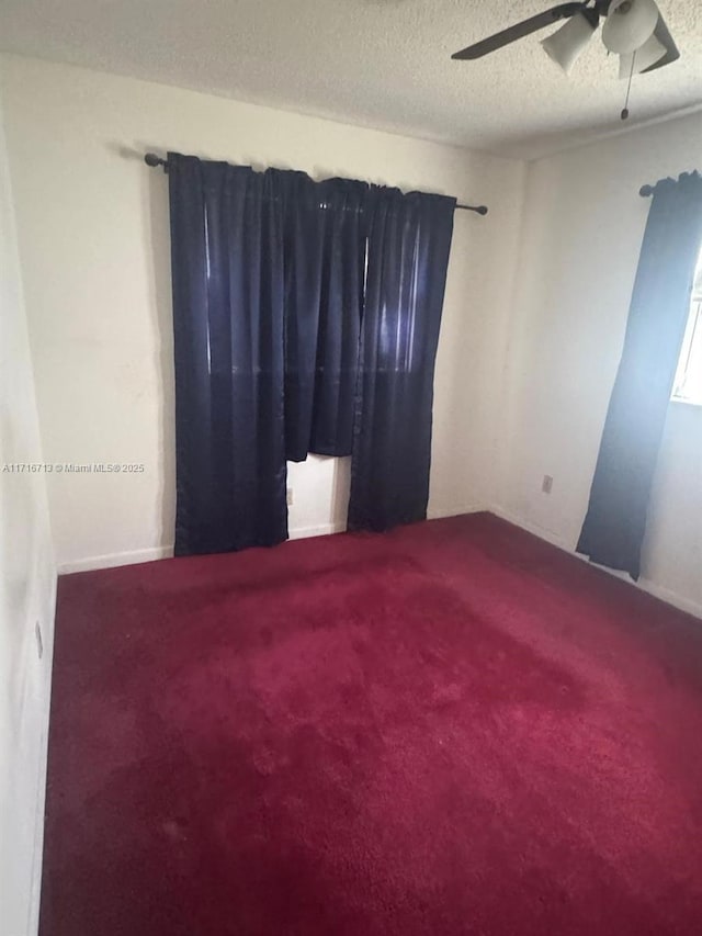 carpeted empty room featuring a textured ceiling and ceiling fan