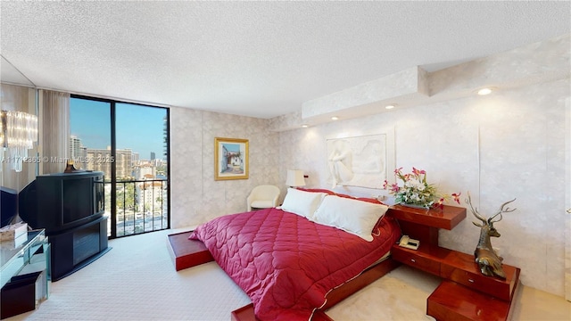 carpeted bedroom featuring expansive windows, access to exterior, and a textured ceiling