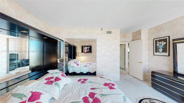 bedroom featuring a textured ceiling, light colored carpet, and a closet