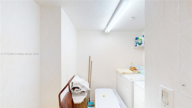 bathroom with beam ceiling and separate washer and dryer