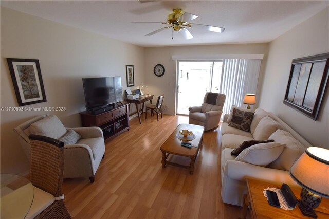 living room with light hardwood / wood-style floors and ceiling fan