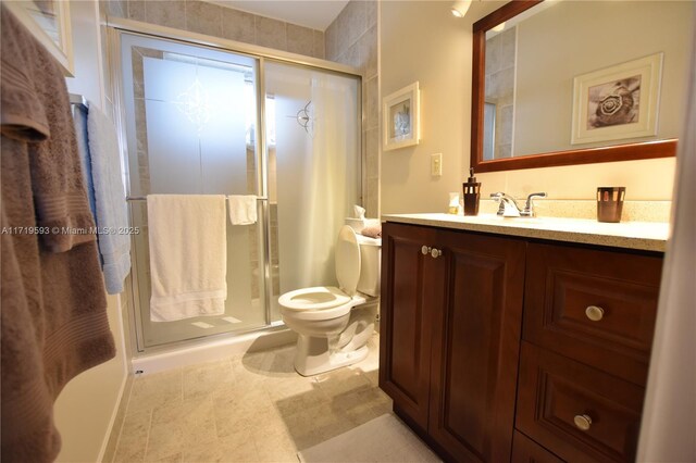 bathroom featuring vanity, a shower with shower door, tile patterned floors, and toilet