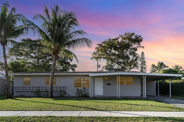 ranch-style house featuring a yard and a carport