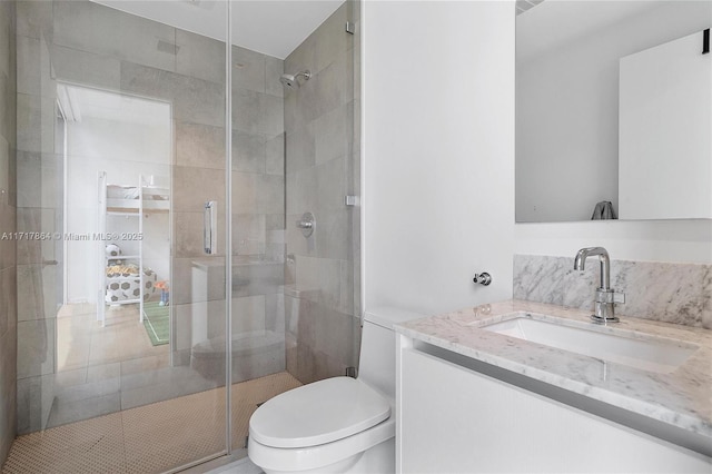 bathroom featuring toilet, an enclosed shower, and vanity