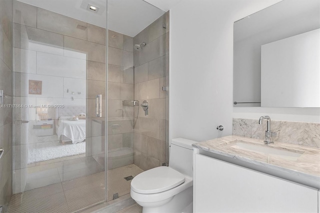 bathroom featuring a shower with shower door, toilet, and vanity