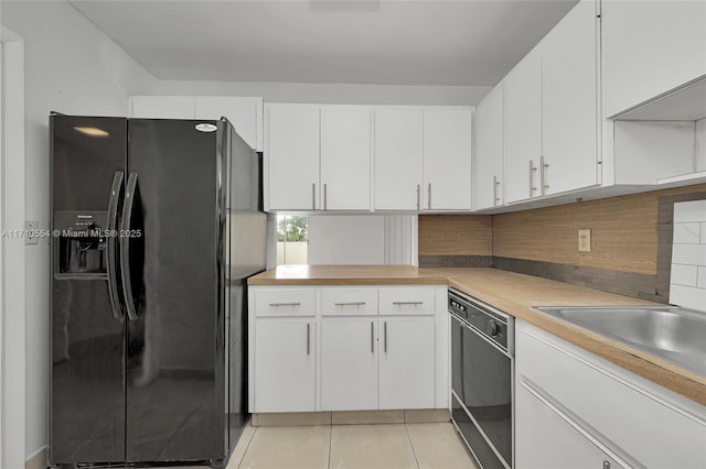 kitchen with black appliances, white cabinetry, backsplash, and light tile patterned floors