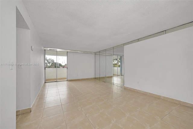 tiled spare room featuring a textured ceiling