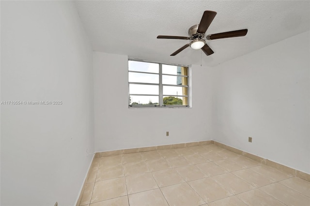 unfurnished room featuring ceiling fan, light tile patterned floors, and a textured ceiling