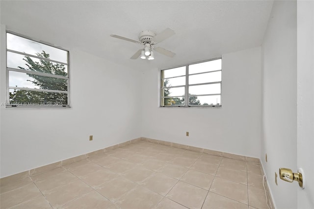 tiled spare room featuring ceiling fan