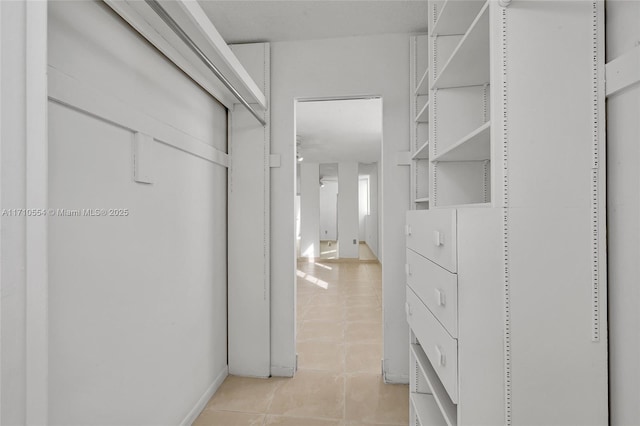 walk in closet with light tile patterned floors