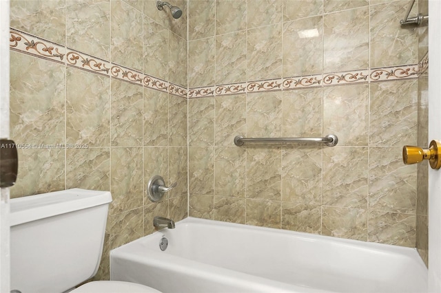 bathroom featuring tiled shower / bath combo and toilet