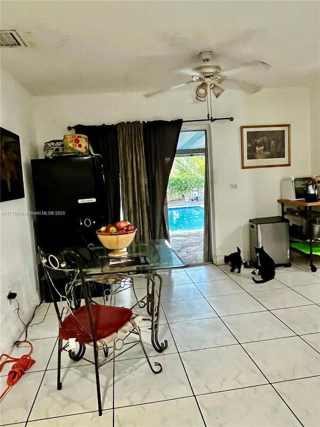 tiled dining space with ceiling fan