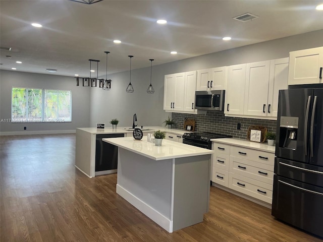 kitchen with decorative backsplash, sink, black appliances, white cabinetry, and hanging light fixtures