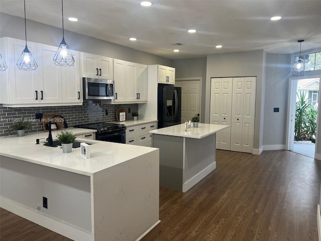 kitchen with black appliances, white cabinets, tasteful backsplash, decorative light fixtures, and a kitchen island