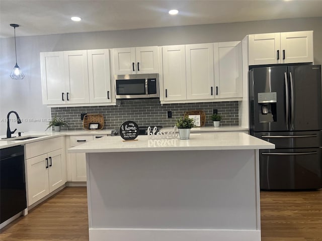 kitchen with dishwasher, sink, hanging light fixtures, refrigerator with ice dispenser, and white cabinets