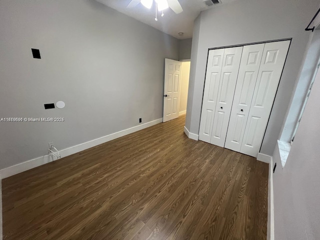 unfurnished bedroom featuring ceiling fan, dark wood-type flooring, and a closet