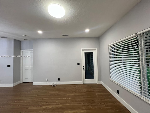 clothes washing area with dark hardwood / wood-style flooring and a textured ceiling