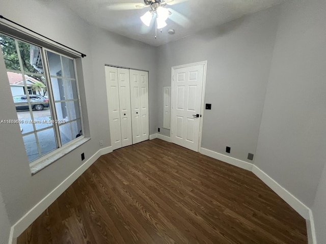 unfurnished bedroom featuring ceiling fan, dark hardwood / wood-style floors, and a closet