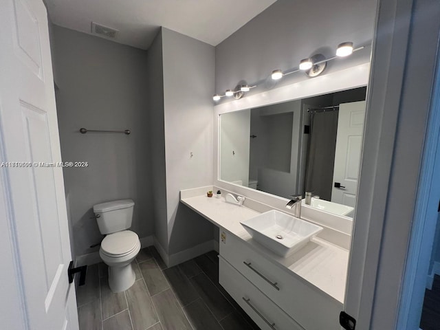 bathroom featuring vanity, toilet, and curtained shower