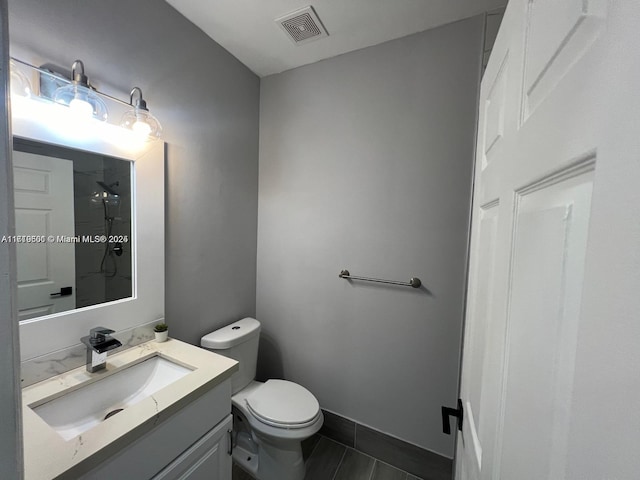 bathroom with a shower, vanity, and toilet