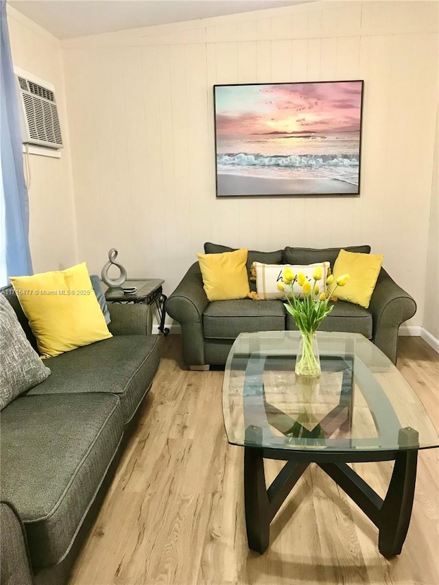 living room featuring a wall unit AC and light hardwood / wood-style flooring