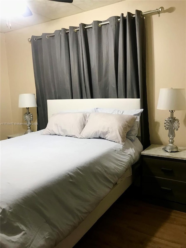 bedroom with dark hardwood / wood-style floors and ceiling fan