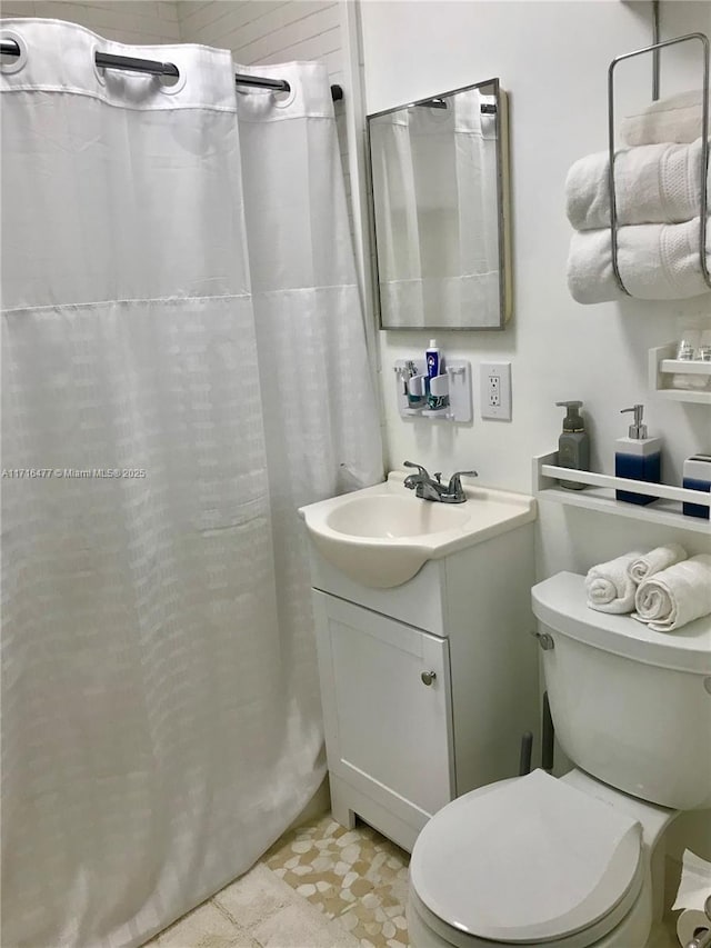 bathroom featuring tile patterned floors, walk in shower, vanity, and toilet