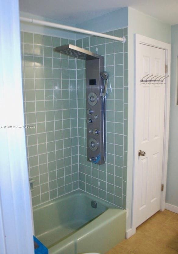 bathroom featuring tile patterned floors and tiled shower / bath