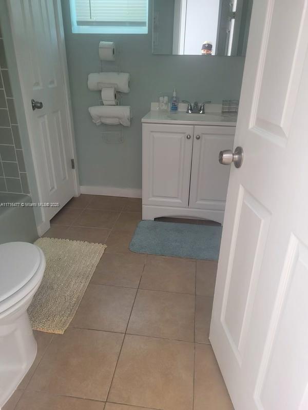 bathroom with tile patterned flooring, vanity, and toilet