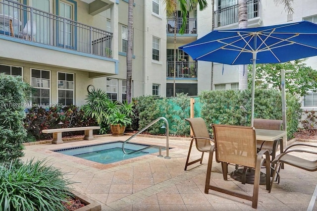 view of swimming pool with a patio area and a hot tub