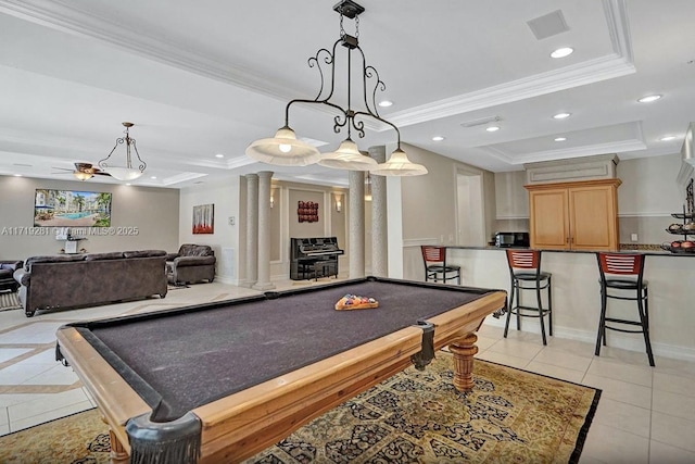 game room featuring light tile patterned floors, decorative columns, pool table, and a tray ceiling