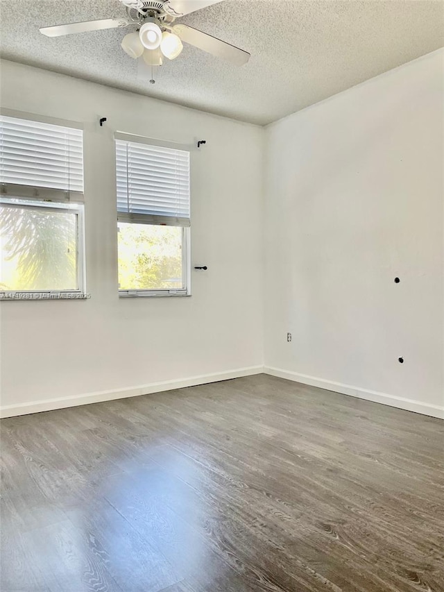 empty room featuring ceiling fan, dark hardwood / wood-style flooring, and a textured ceiling