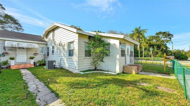 view of side of property featuring a lawn and central air condition unit